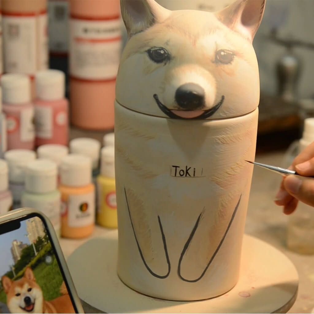 Professional artist hand-painting 3D relief details on a Hollow Paw custom pet memorial urn